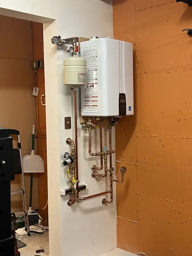 Plumbing technician inspecting water heater connections in Bushland
